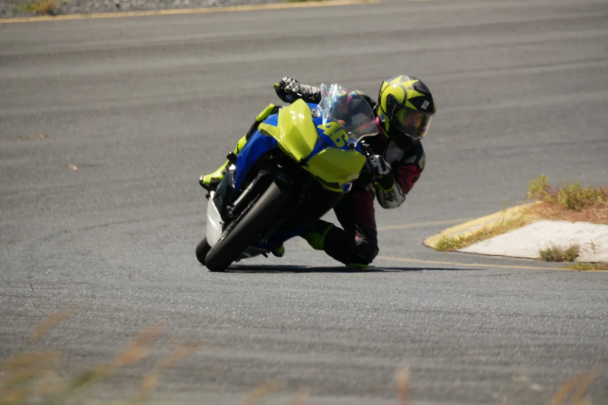 Motocicleta azul y amarilla inclinada en curva